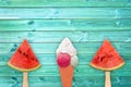 Watermelon popsicles and ice cream cone on blue planks background, summer concept