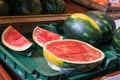Watermelon ready to sell cut in half and pieces in a green plastic box at local market. Tropical healthy product open to being