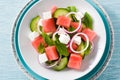 Watermelon salad with feta cheese,mint,onion and cucumber on blue background. Royalty Free Stock Photo