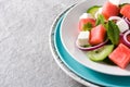 Watermelon salad with feta cheese,mint,onion and cucumber on gray background. Royalty Free Stock Photo