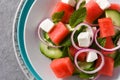 Watermelon salad with feta cheese,mint,onion and cucumber on gray background. Royalty Free Stock Photo