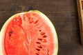 Watermelon with seeds, cut in half close up and copy space. A large ripe watermelon on the background of a textural wooden table Royalty Free Stock Photo