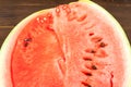 Watermelon with seeds, cut in half close up and copy space. A large ripe watermelon on the background of a textural wooden table Royalty Free Stock Photo