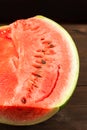 Watermelon with seeds, cut in half close up and copy space. A large ripe watermelon on the background of a textural wooden table Royalty Free Stock Photo