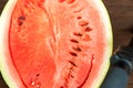 Watermelon with seeds, cut in half close up and copy space. A large ripe watermelon on the background of a textural wooden table Royalty Free Stock Photo