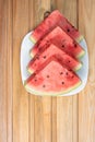 Watermelon in slice on a white crockery on wood, top view