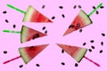 Watermelon slices cut into triangles on sticks, watermelon bones. Pink background.