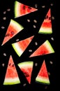 Watermelon slices cut into triangles, watermelon bones. Black background.