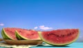 Watermelon slices on a wooden table - blue sky background Royalty Free Stock Photo