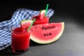 Watermelon smoothies with a slice of ripe watermelon on a black background