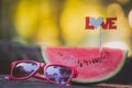 Watermelon and sunglasses on table outdoors