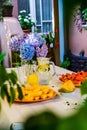 Watermelon triangle slices, yellow orange Mellon slices and lemonade on a table. A vase with flowers in the background Royalty Free Stock Photo