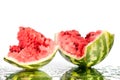 Watermelon halves pieces with cracks and water drops on white mirror background with reflection isolated close up Royalty Free Stock Photo