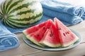 watermelon wedges on a plate beside beach towels