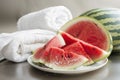 watermelon wedges on a plate beside beach towels