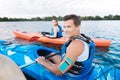 Handsome sportsman having his phone in waterproof case while kayaking