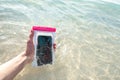 Waterproof case on a smartphone, phone for taking pictures under water. Phone in the waterproof case underwater, on the sands