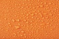 Waterproof clothing or upholstered furniture made from waterproof textiles. Drops of water on orange textiles with water Royalty Free Stock Photo