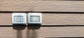 Waterproof electrical sockets installed outdoors on dark wooden walls. Royalty Free Stock Photo