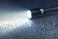 Waterproof flashlight on wet surface with beam Royalty Free Stock Photo