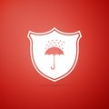 Waterproof icon isolated on red background. Shield and umbrella. Water protection sign. Water resistant symbol