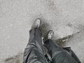 Waterproof trouser and rain gumboots to protect two legs of a man stands on the flooded road in severe weather cyclone raining