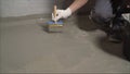 The process of priming the floor with a solution. Waterproofing a concrete floor. repair cracked floor in front of a