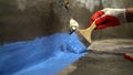 Waterproofing the floor with a brush.Waterproofing concrete mortar. The master puts waterproofing on a concrete floor