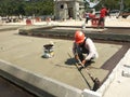 Waterproofing membrane applied by construction workers on top of the concrete slab.