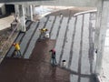 Waterproofing membrane applied by construction workers on top of the concrete slab.