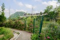 Waterside fenced flowering path with ancient Qingyan town in dis