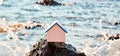 Waterside house. Property acquisition. Real estate market. Wooden house on sea shore mockup. Sea breeze, rock and waves