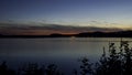 Waterside of a lake with bushes in colorful dusk with clouds time lapse