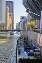 Waterside patio on Chicago canal with tour boats passing under bridge with line of skyscrapers Royalty Free Stock Photo