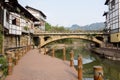 Waterside planked path before aged bridge in ancient town Royalty Free Stock Photo