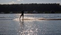 Waterskier silhouette moving fast in splashes of water at sunset