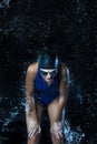 Watersports Concepts. Sportive Caucasian Female Swimmer in Swimsuit Posing in Goggles in Aqua Studio With Multiple Water Droplets