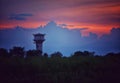 watertank far from the nature with red and blue sky with dark clouds and trees Royalty Free Stock Photo