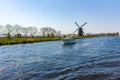 Waterways of North Holland with boats and view on traditional Dutch mill, spring landscape