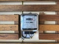 Watt hour electric meter measurement tool on wooden wall Royalty Free Stock Photo