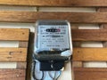 Watt hour electric meter measurement tool on wooden wall Royalty Free Stock Photo