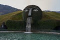 Wattens, Austria - March 18, 2023 - a fountain with giant head spitting water into a pond at Swarovski Kristallwelten