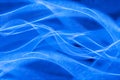 Abstract background of intertwining neon threads in the form of waves in blue colors.