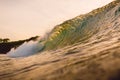 Wave barrel in ocean at sunset or sunrise. Wave crashing