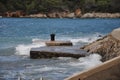 Stone pier with rusty bollard. Completely rusted dilapidated iron mooring bollard in middle of stone pier. Royalty Free Stock Photo