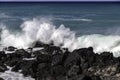 Wave Breaking on black volcanic rocks, Hawaiian coast. Blue-green pacific ocean in distance Royalty Free Stock Photo