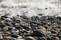 A wave breaking on a pebble beach, close-up. Royalty Free Stock Photo