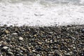 A wave breaking on a pebble beach, close-up. Royalty Free Stock Photo