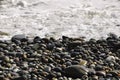 A wave breaking on a pebble beach, close-up. Royalty Free Stock Photo