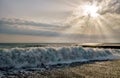 Wave breaking on pebble sea shore at sunset. Scenic landscape at Khosta beach, Sochi, Russia